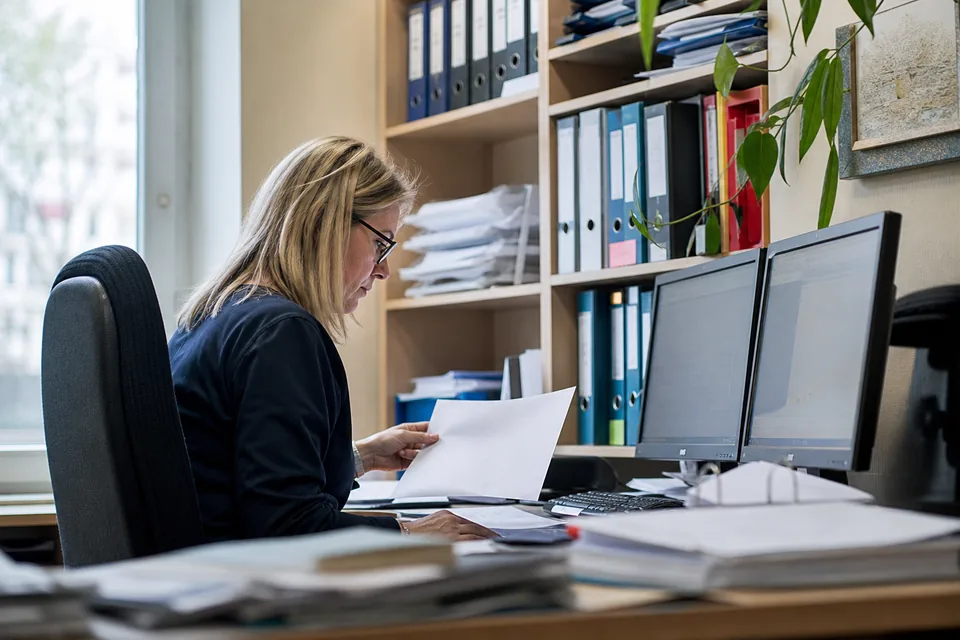 Księgowa w biurze rachunkowym przegląda listę kontrahentów klienta na dwóch monitorach