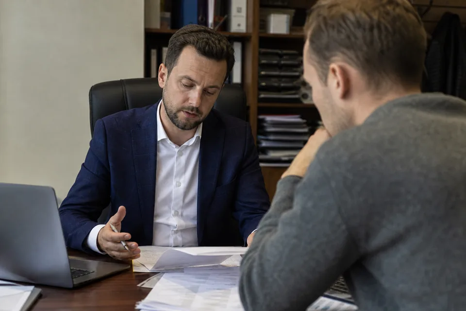 Księgowy omawia z właścicielem firmy listę odbiorców z zaległymi fakturami