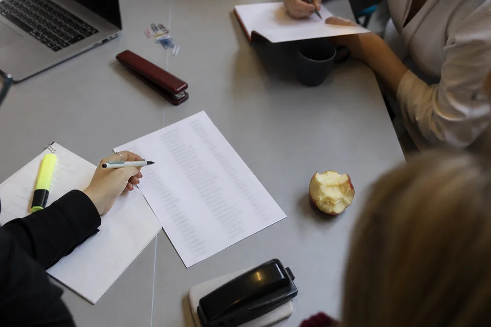 Kobieta przegląda dane kontrahentów w arkuszu na komputerze w jasnym biurze